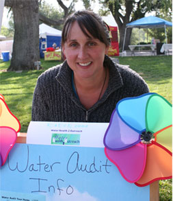 Maria Kelly in front of WH2O's water audit sign